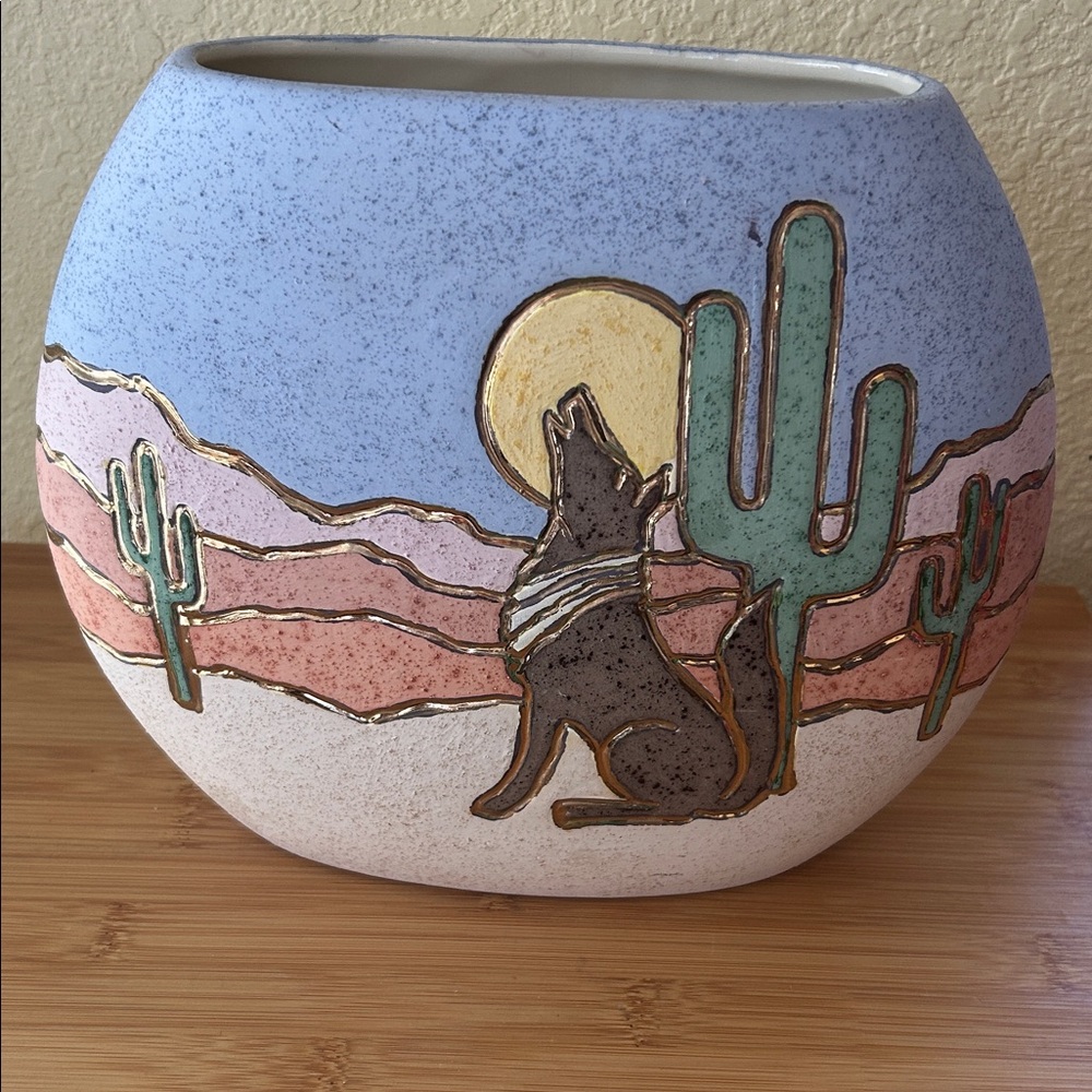 Southwestern art pottery with howling coyote and cactus vase.